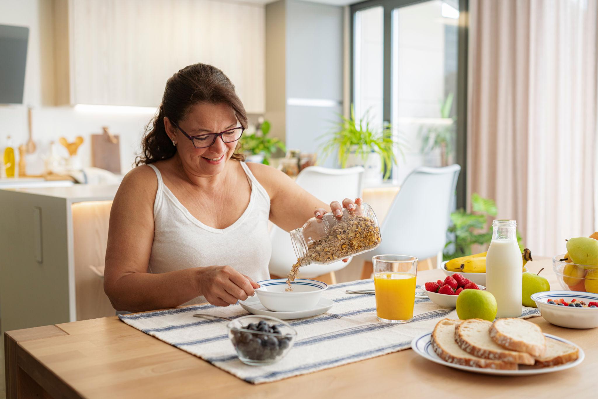 Mulher fazendo uma refeição equilibrada em casa, representando a retomada da alimentação e da vida habitual após a retirada da vesícula